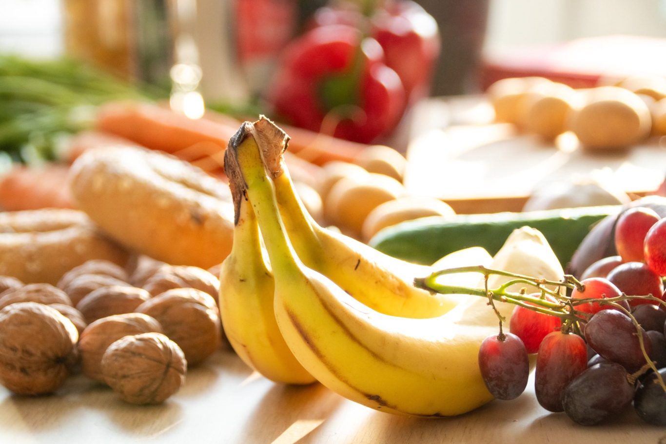 Obst & Gemüse Bunte Auswahl an Obst und Gemüse, darunter Bananen, Trauben und Karotten.