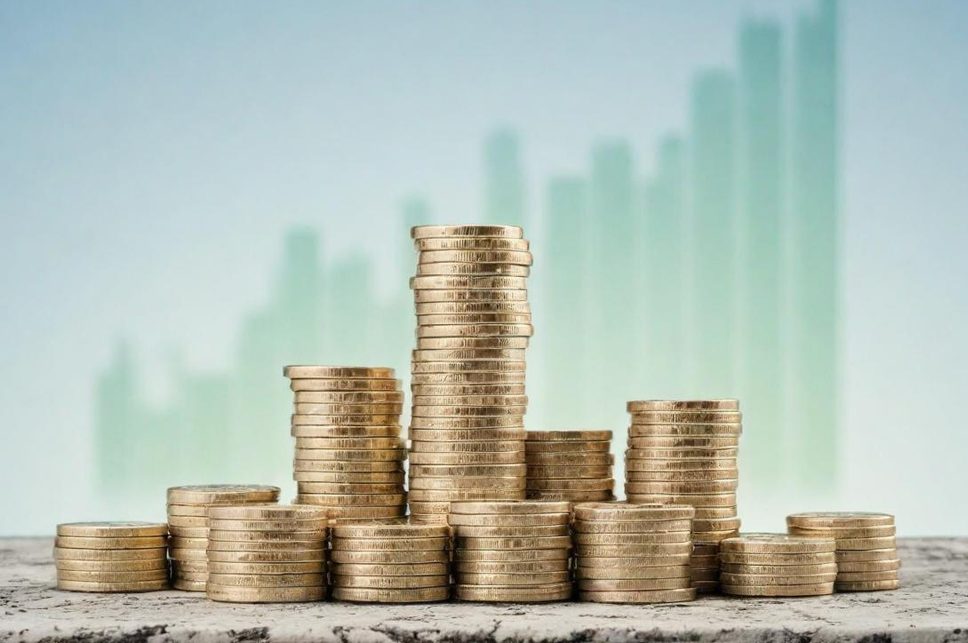 Finanzen Stapelhaufen von Münzen vor einem aufsteigenden Diagramm.